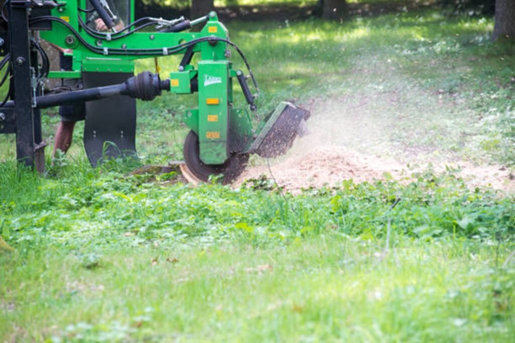 Stump grinding machine removing a tree stump and wood chips in a residential yard in Beachwood, OH